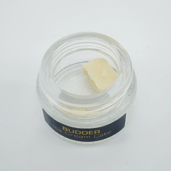 Close-up of Factory 710 Budder in a clear container. High-quality cannabis concentrate with a creamy, smooth texture. Ideal for connoisseurs seeking premium extracts.