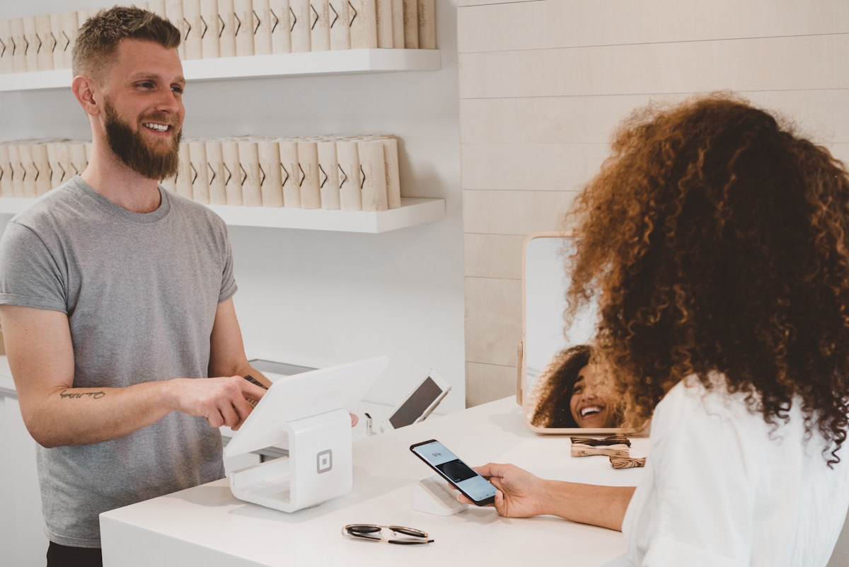 Customer making a mobile payment at a retail store, showcasing a seamless point-of-sale experience and modern business transaction.