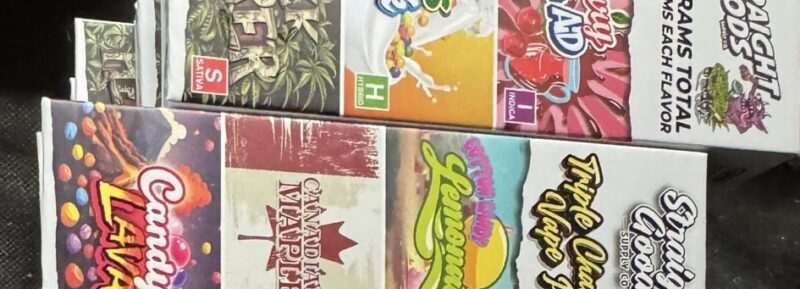 A collection of colorful vape juice boxes showcasing various flavors and brands arranged neatly.