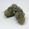 Grape Ape AA indica cannabis flower buds, dark purple-tinged nugs with frosty trichomes, THC 16-19%